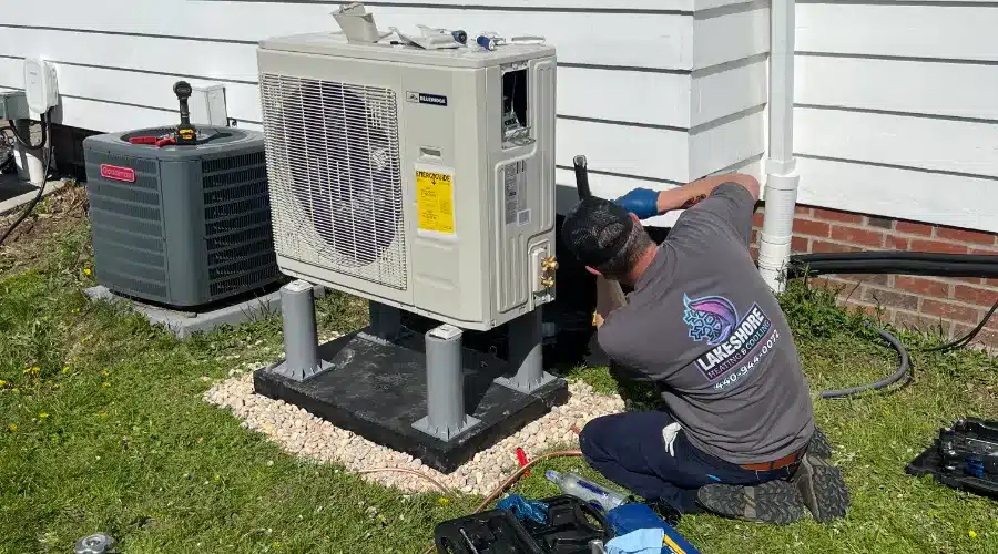 A Lakeshore Heating & Cooling Technician Repairing A Clients Heat Pump.